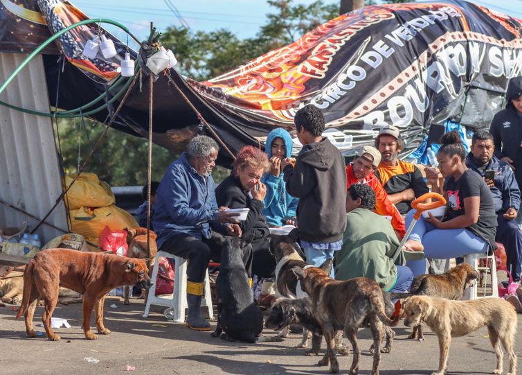 Famílias improvisam acampamentos em rodovias à vigiar suas casas no RS